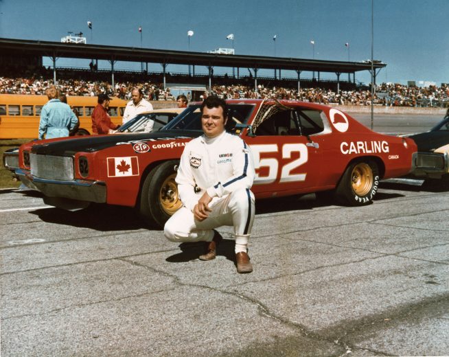 Earl Ross poses next to car at Daytona.
