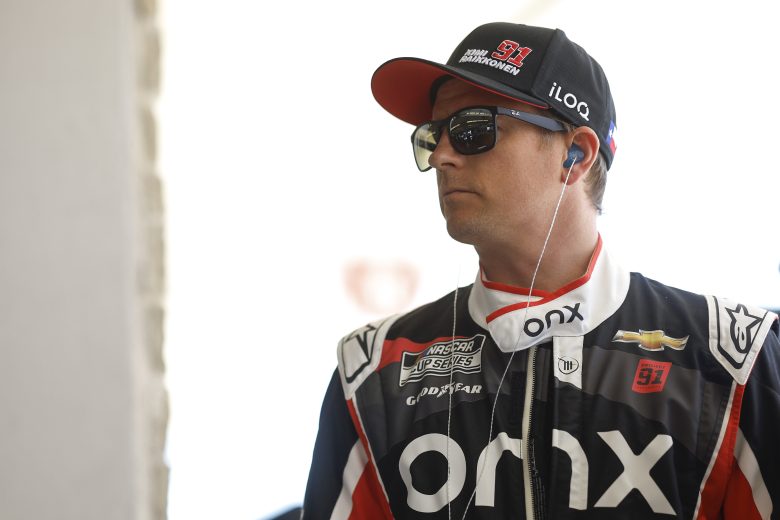Kimi Raikkoen looks on.