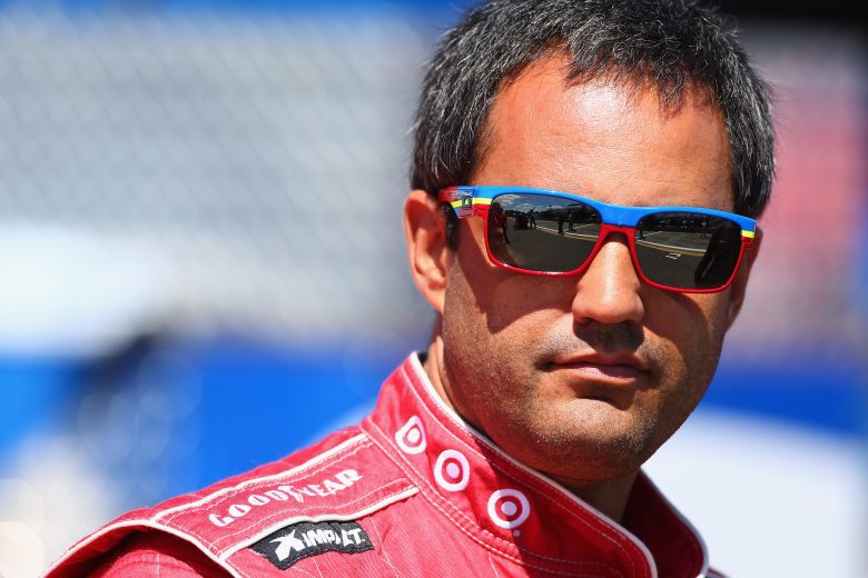 Juan Pablo Montoya looks on in sunglasses.