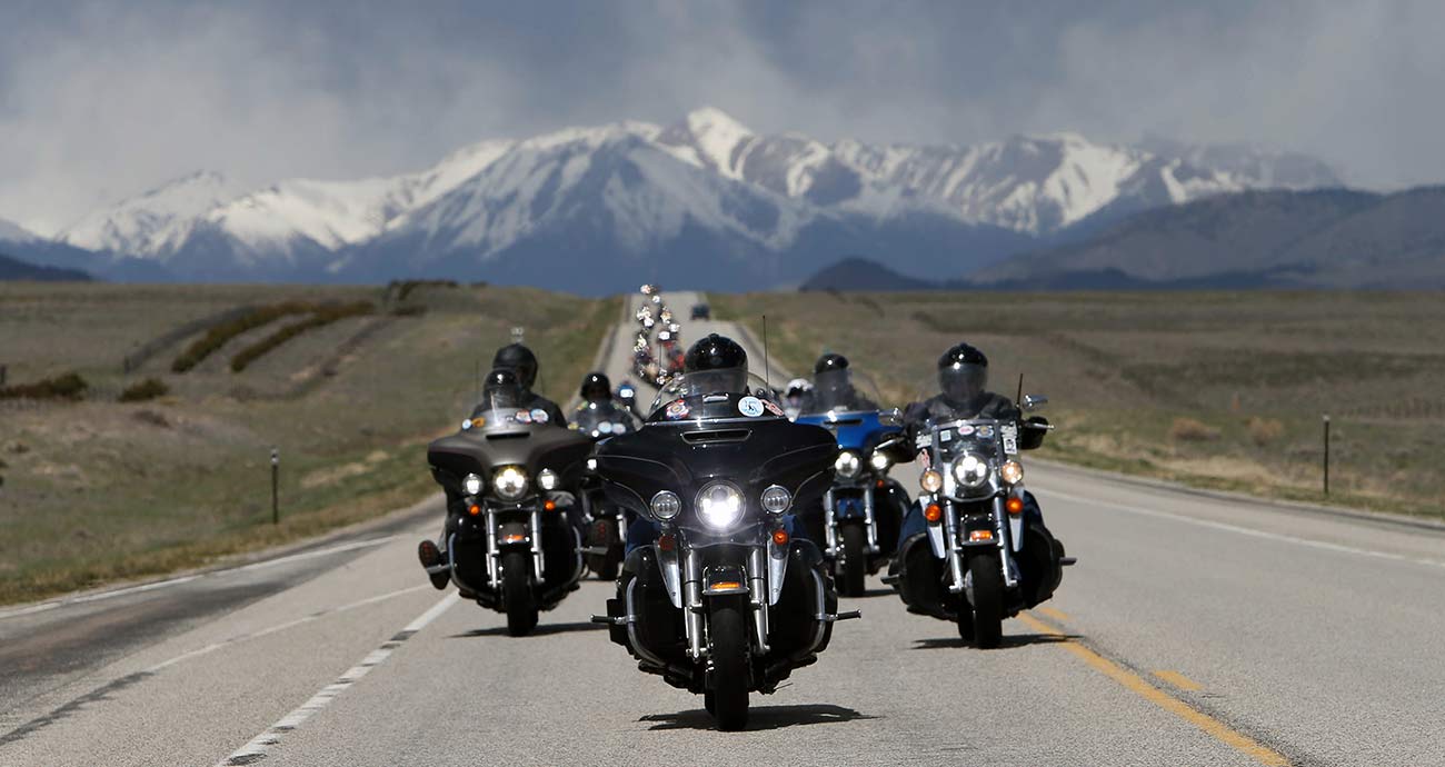 Riders on the Kyle Petty Charity Ride, with a majestic mountain backdrop to the open road