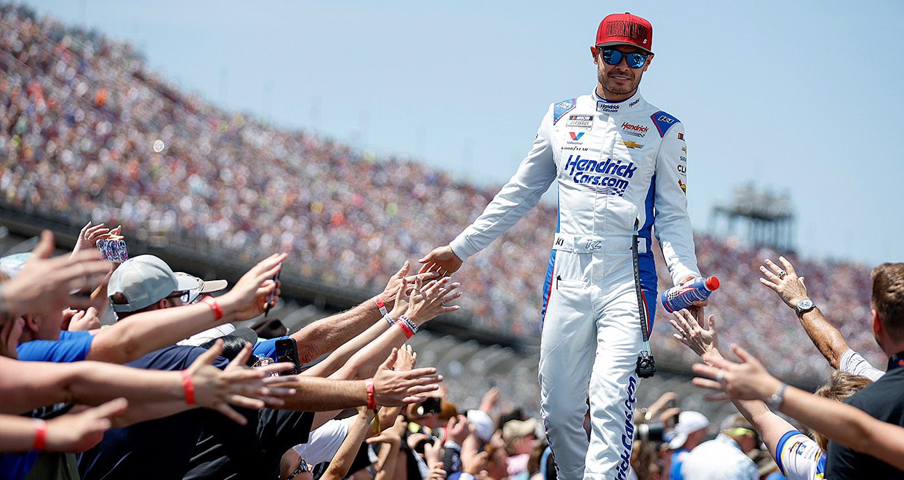Kyle Larson high fives fans during driver intros.