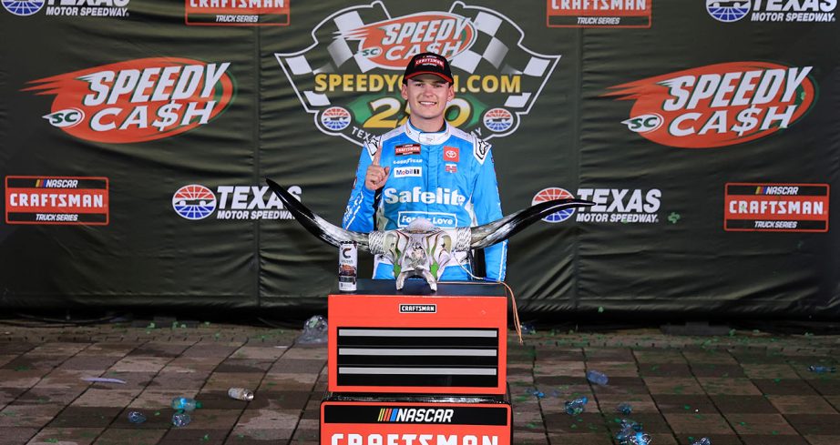 Corey Heim stands in Victory Lane with trophy.