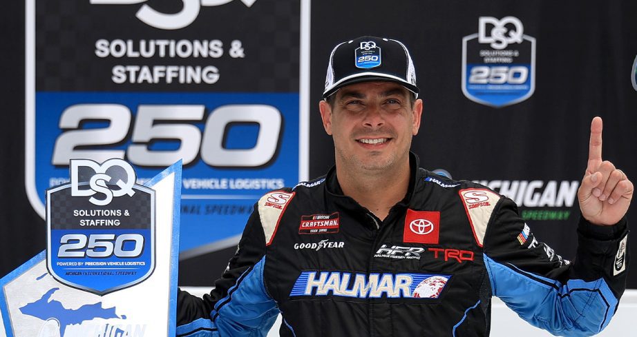 Stewart Friesen stands in Victory Lane at Michigan International Speedway.