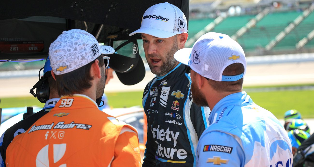 Shane van Gisbergen talks with Trackhouse teammates Daniel Suárez and Ross Chastain.