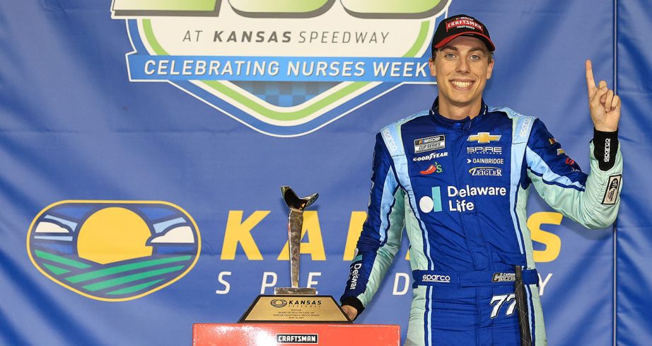 Carson Hocevar stands in Victory Lane with trophy.