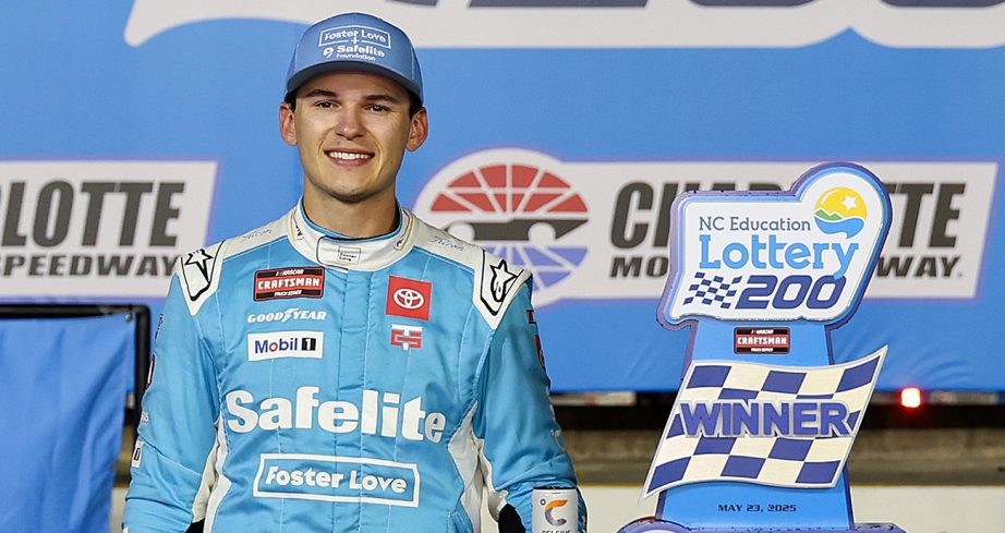 Corey Heim smiles next to trophy in Victory Lane.