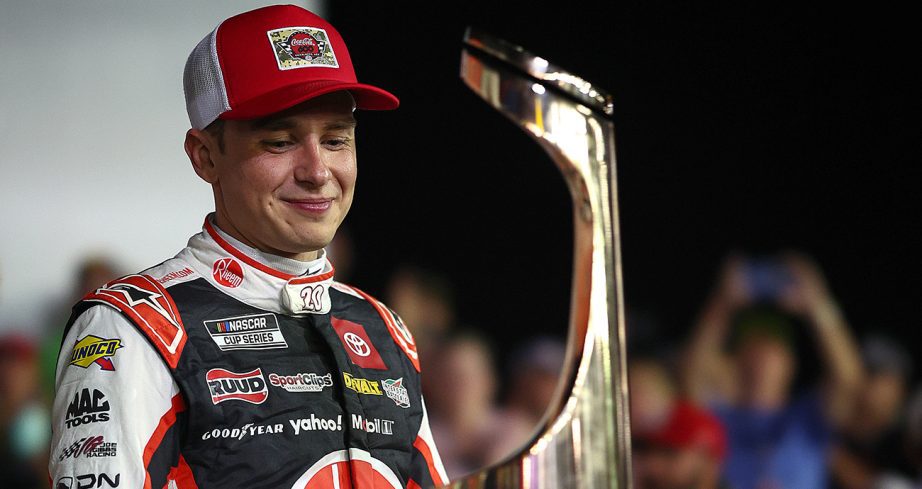 Christopher Bell smiles and looks at Charlotte trophy.