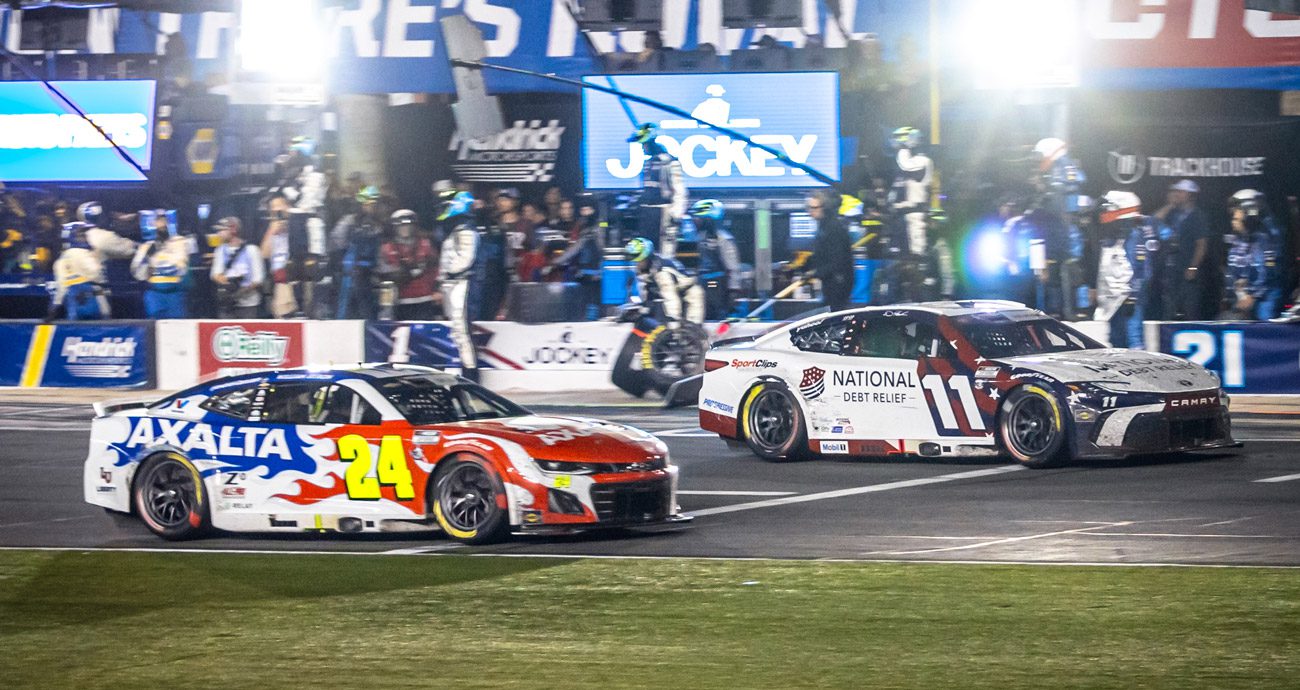 Denny Hamlin and William Byron race for the lead in the Coca-Cola 600 off pit road at Charlotte.