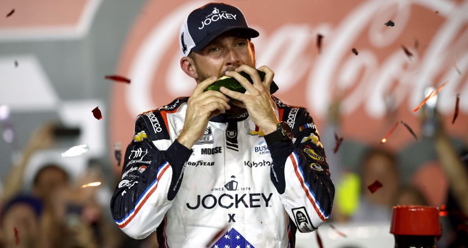 Ross Chastain bites into watermelon in Victory Lane following his NASCAR Cup Series win at Charlotte Motor Speedway.