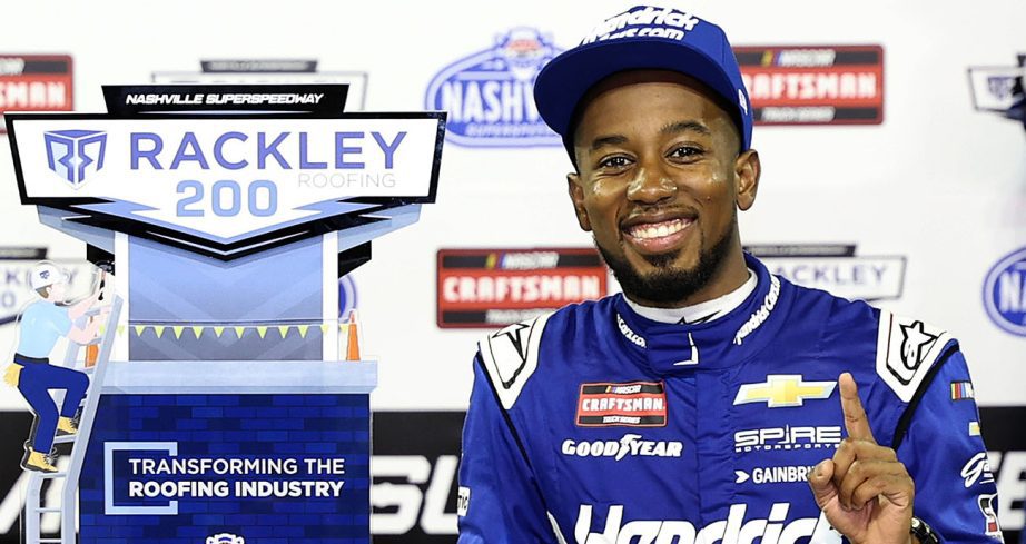 Rajah Caruth smiles next trophy in Victory Lane.