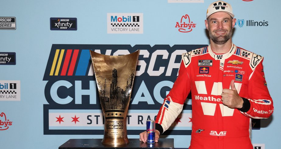 Shane van Gisbergen stands in Victory Lane with the trophy at the Chicago Street Course.