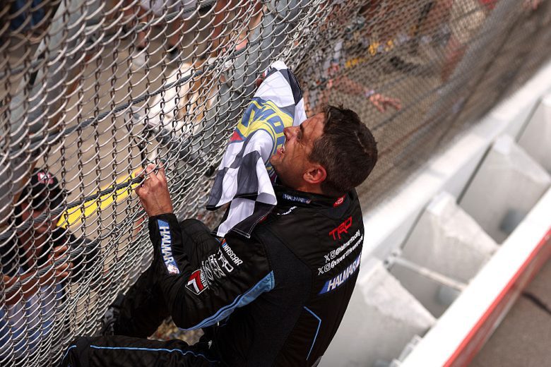 Stewart Friesen climbs the fence after winning at Michigan.