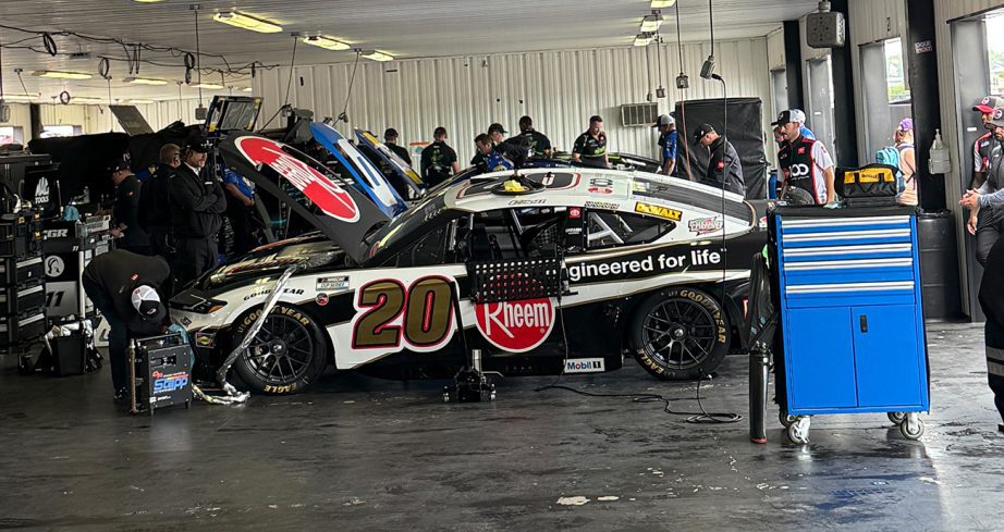 NASCAR Cup Series teams work on race cars during a weather delay before the Cup Series race at Pocono Raceway.