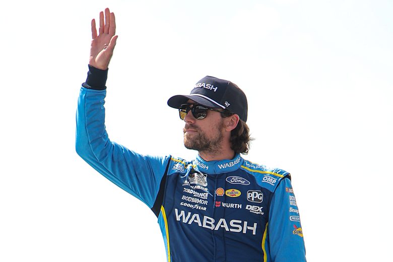 Ryan Blaney waves to fans while onstage.