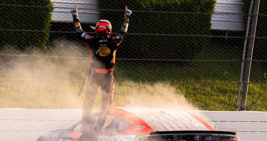 Chase Briscoe stands atop his No. 19 Toyota and celebrates following his NASCAR Cup Series win at Pocono Raceway.