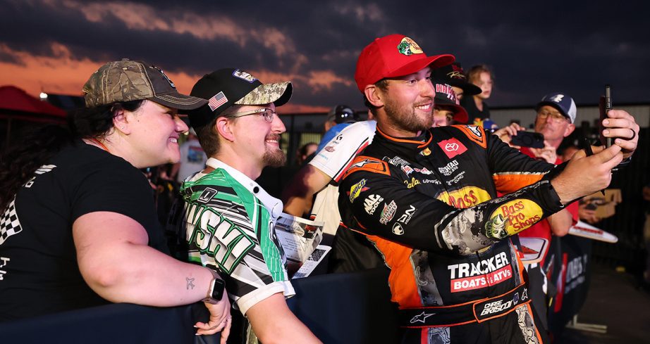 Chase Briscoe smiles with fans as he takes a selfie.