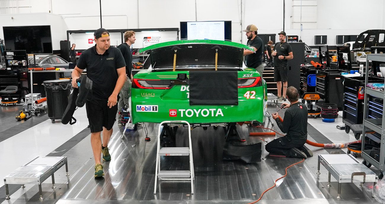 Legacy Motor Club members work on John Hunter Nemechek's race car.