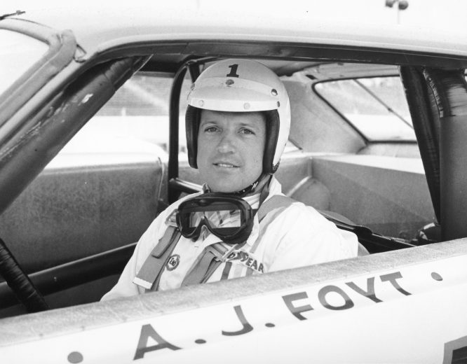 A.J. Foyt smiles and looks on from driver seat of his stock car at Riverside.