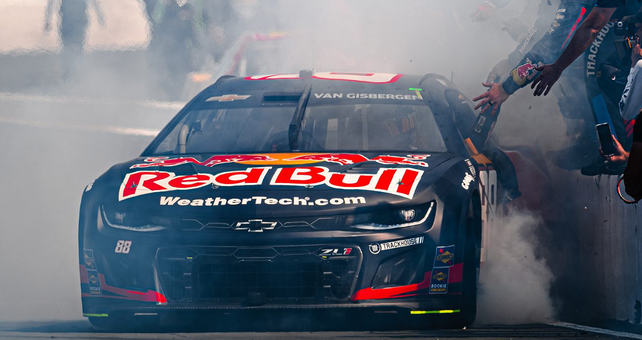 Shane van Gisbergen gives high-fives to his crew members while doing a burnout.