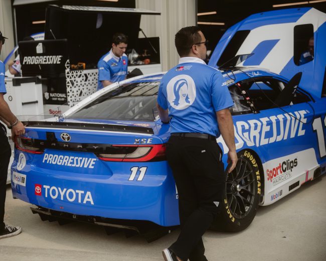 Joe Gibbs Racing crew members work on the No. 11 Toyota in garage area at Dover Motor Speedway.