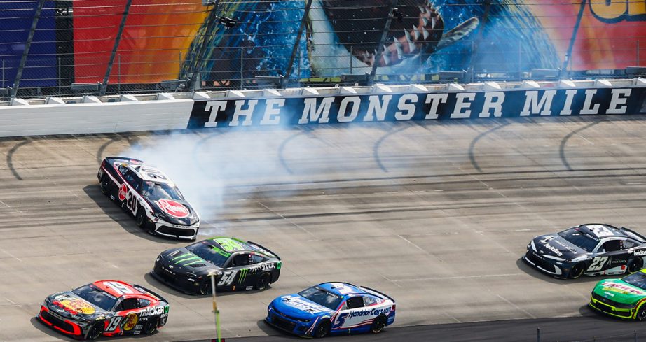 The Cup Series field drives around the No. 20 Toyota of Christopher Bell after his spin from the lead.