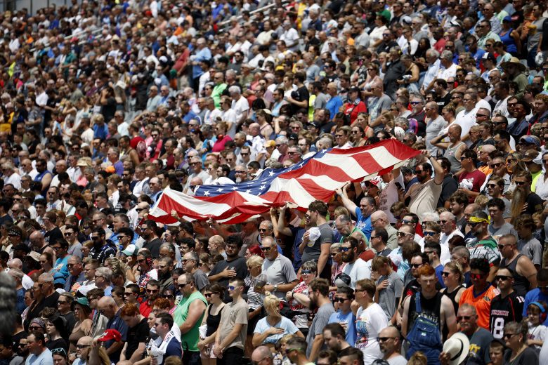 Fans wave the American flag in grandstands.
