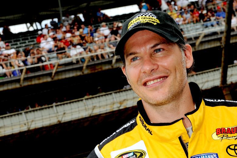 Jacques Villeneuve smiles and looks on.