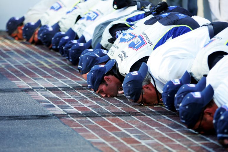 Jimmie Johnson and his team kiss the yard of bricks at Indy.
