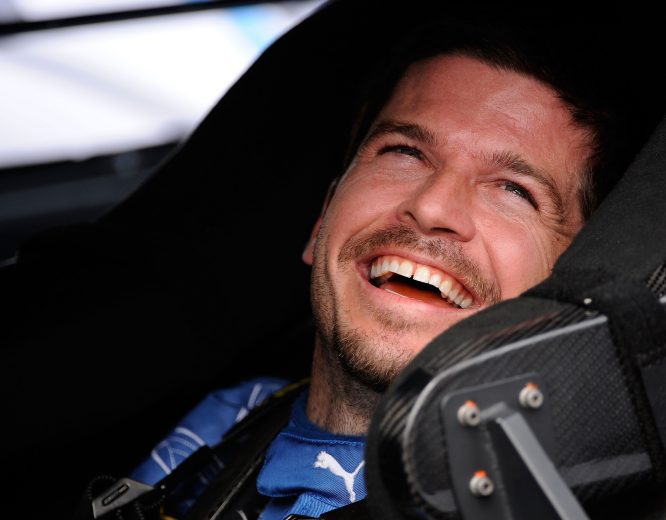 Patrick Carpentier laughs from the seat of his car.