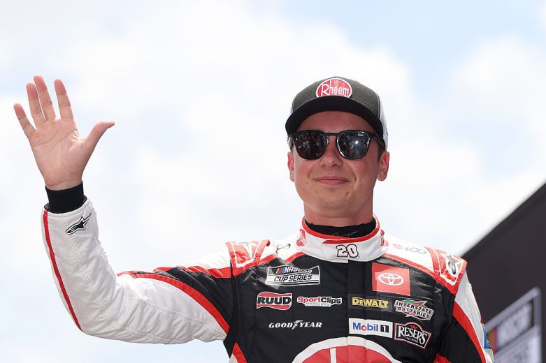 Christopher Bell looks on.