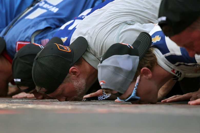 The No. 88 JR Motorsports team kisses the bricks at Indianapolis.