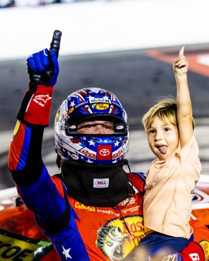Chase Briscoe (L) and his son, Brooks (R) point to the crowd.