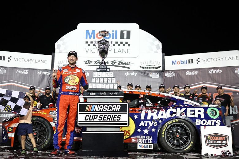 Chase Briscoe poses for a photo with the Southern 500 trophy while standing in front of his No. 19 Joe Gibbs Racing Toyota at Darlington Raceway.