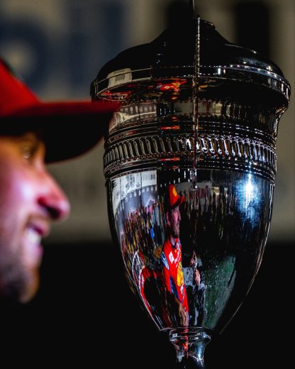 A close-up view of the Southern 500 trophy with Briscoe standing next to it in the background.