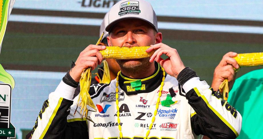 William Byron bites into an ear of corn in Victory Lane at Iowa Speedway