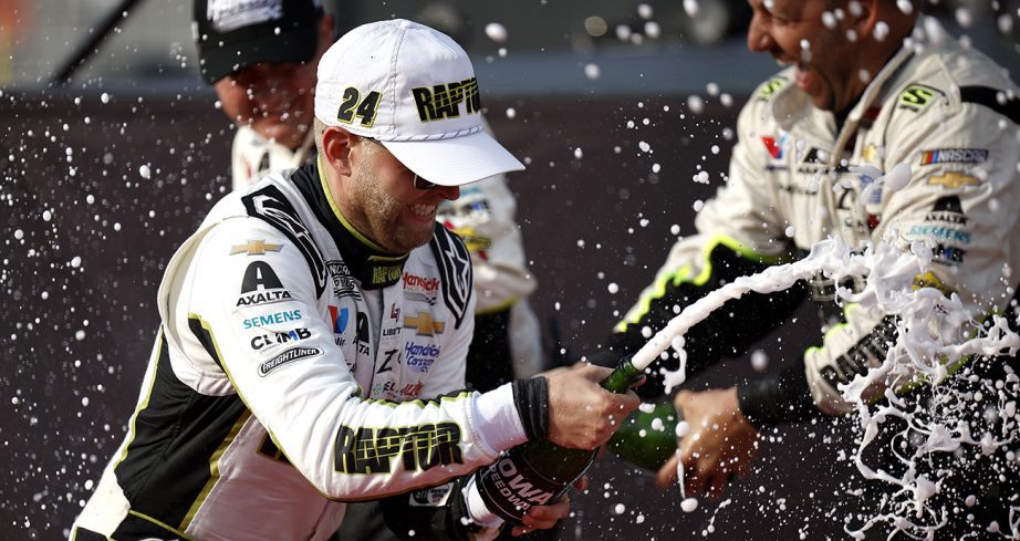 William Byron celebrates with champagne in Victory Lane at Iowa Speedway.
