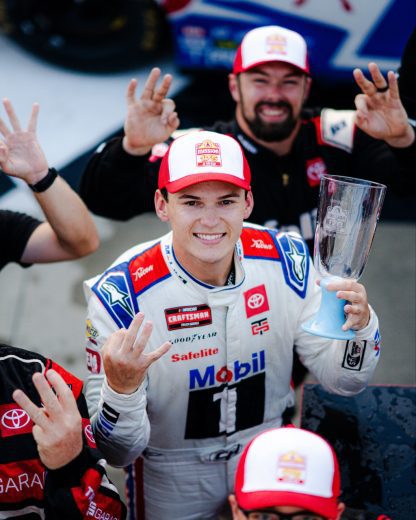 Corey Heim smiles and poses for a photo following his NASCAR Craftsman Truck Series win at Watkins Glen International.