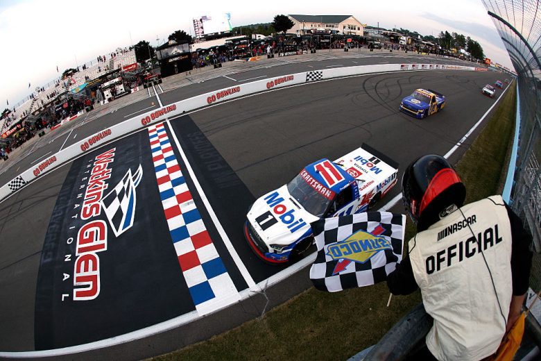 Corey Heim's No. 11 Tricon Garage Toyota crosses the start/finish line as the checkered flag waves during a NASCAR Craftsman Truck Series race at Watkins Glen International.