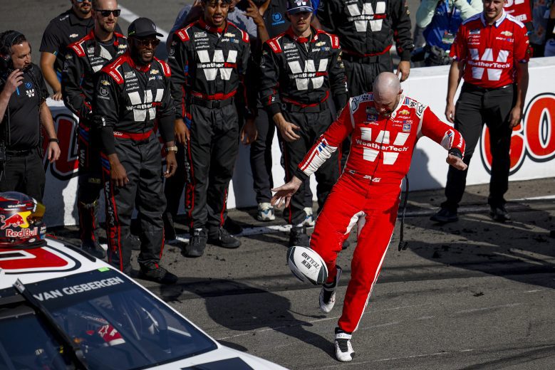 Shane van Gisbergen kicks a rugby ball following his NASCAR Cup Series win at Watkins Glen International.