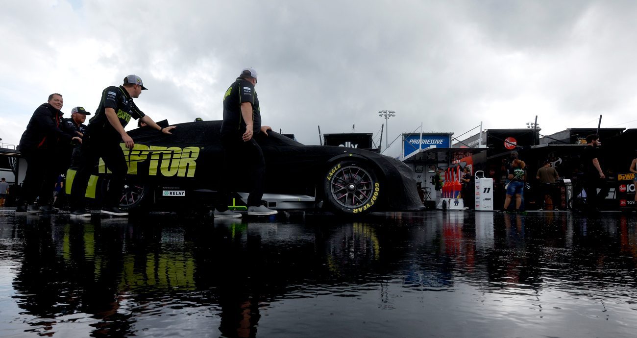 Crew members push the No. 24 Raptor Chevrolet, driven by William Byron, in the garage area during a weather delay of practice for the NASCAR Cup Series AutoTrader EchoPark Automotive 400 at Dover Motor Speedway on July 19, 2025 in Dover, Delaware.