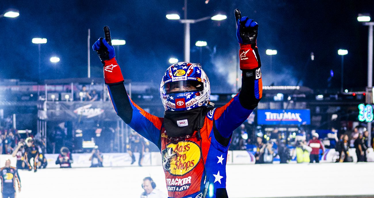 Chase Briscoe celebrates on top of car.