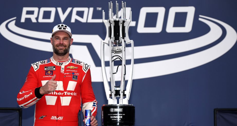 Shane van Gisbergen poses with trophy in Victory Lane at Charlotte Motor Speedway.