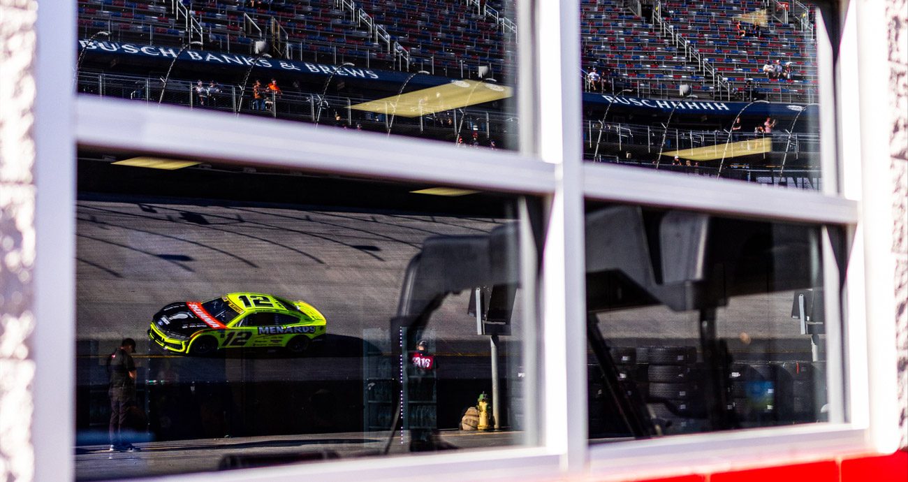 Ryan Blaney drives at Bristol, seen through a window.