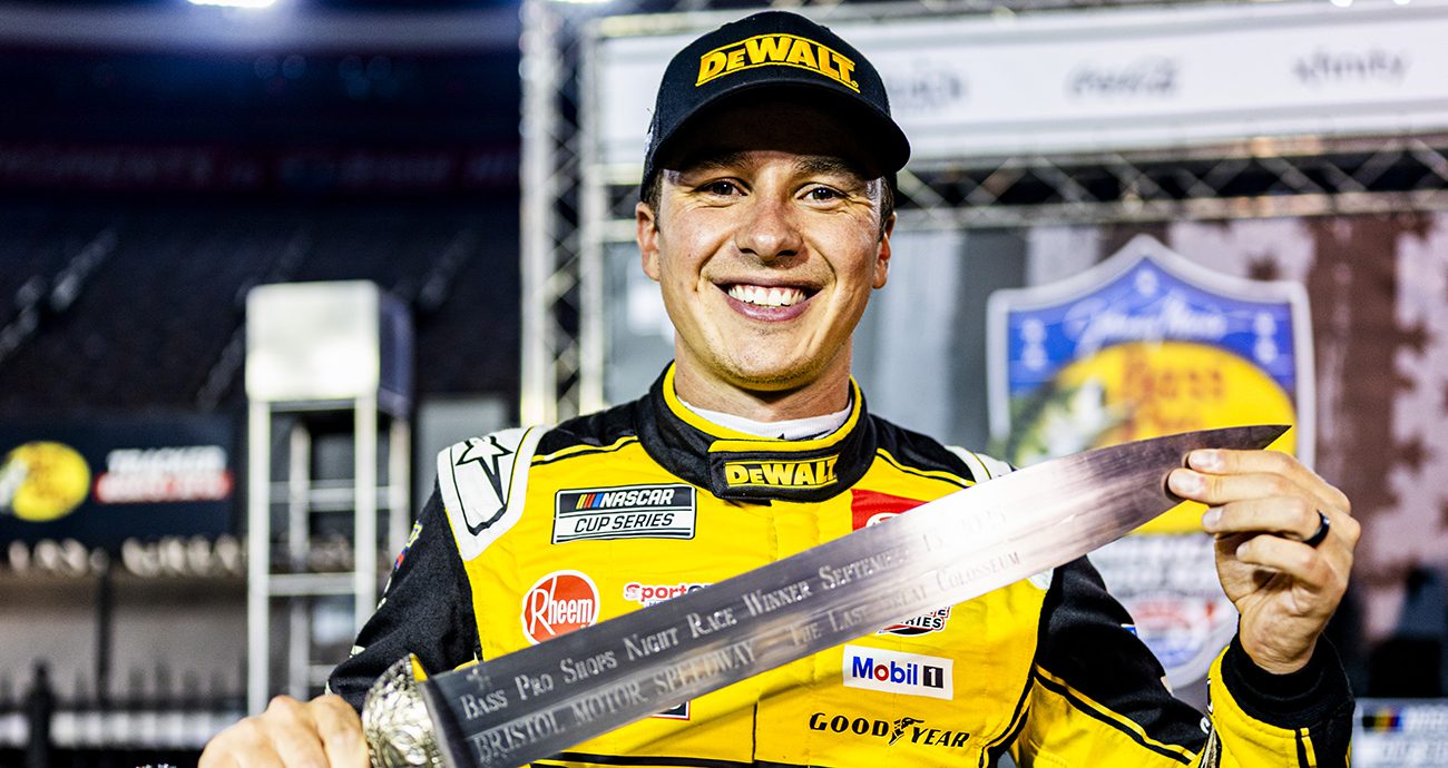 Christopher Bell holds up sword in Victory Lane.