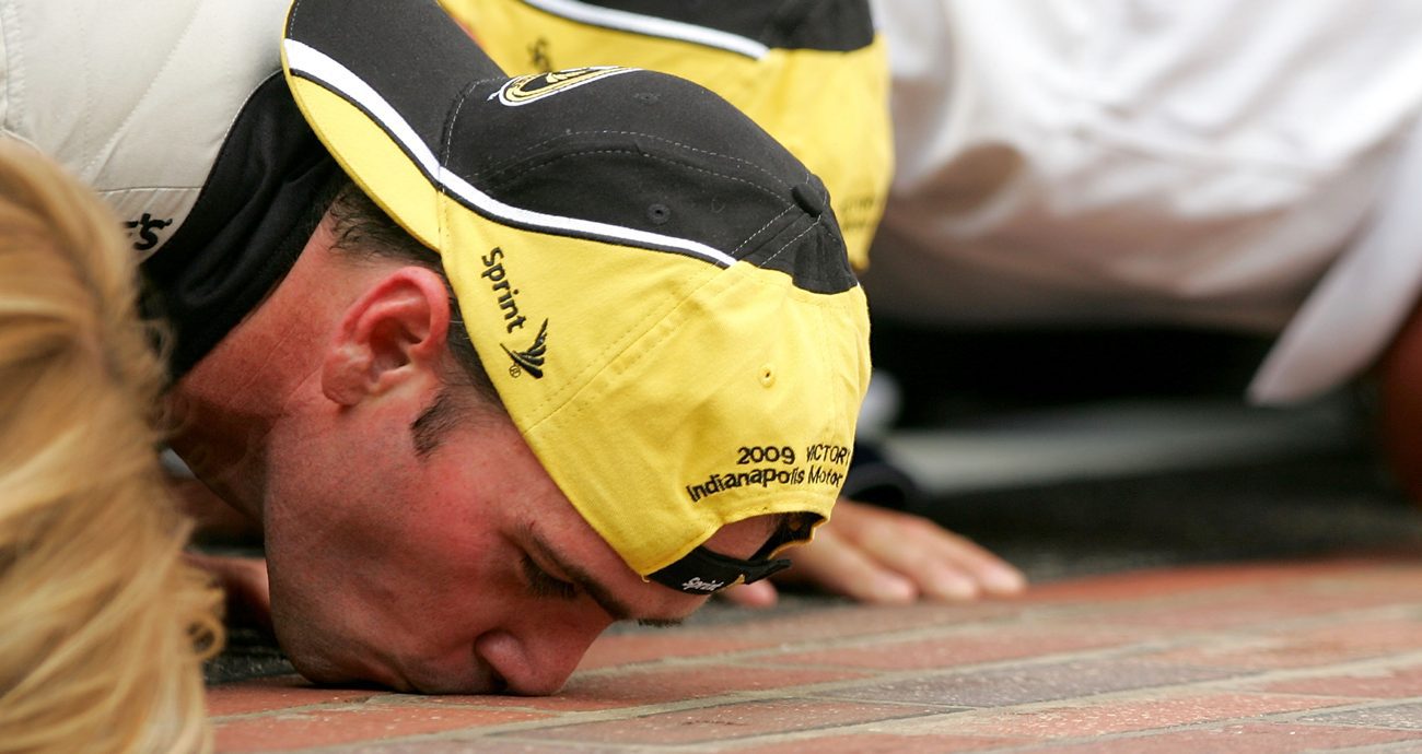 Jimmie Johnson, driver of the No. 48 Lowe's/KOBALT Tools Chevrolet, celebrates by kissing the bricks after winning the NASCAR Cup Series Allstate 400 at the Brickyard at Indianapolis Motor Speedway on July 26, 2009 in Indianapolis, Indiana.