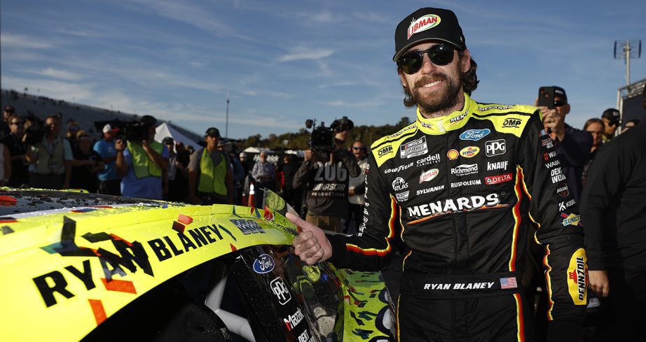 Ryan Blaney puts winner sticker on car in Victory Lane.