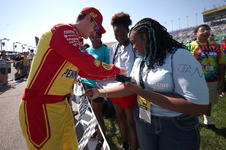 Joey Logano signs autographs before racing at Kansas.