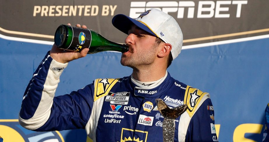 Chase Elliott celebrates a Kansas win by drinking champagne in Victory Lane.