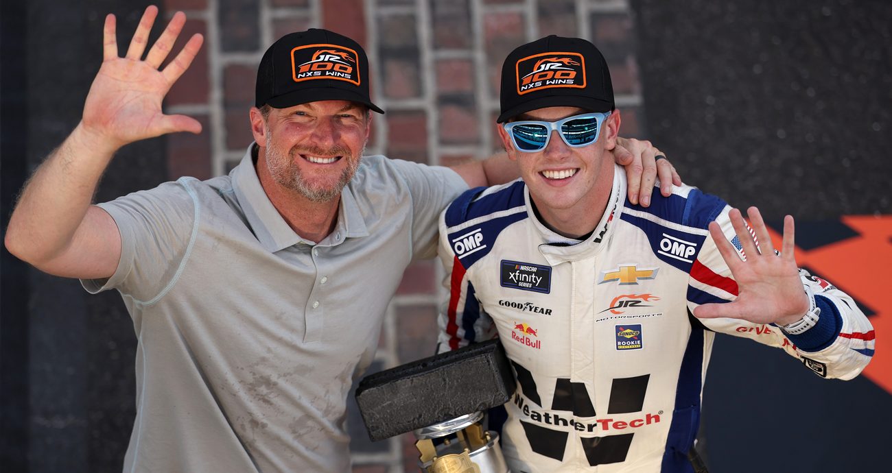 Dale Earnhardt Jr. and Connor Zilisch pose near the yard of bricks at Indianapolis Motor Speedway.