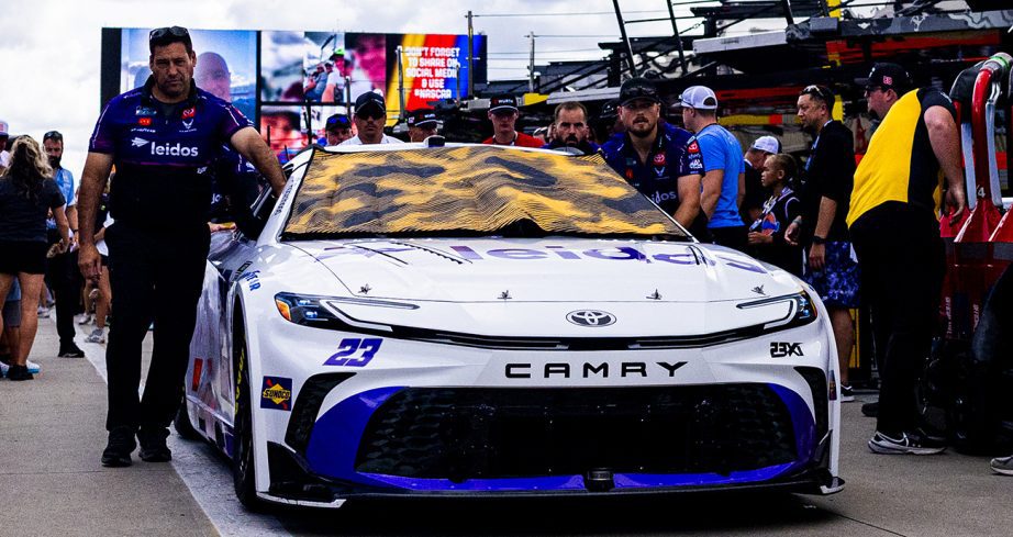 23XI Racing crew push No. 23 Toyota to grid.